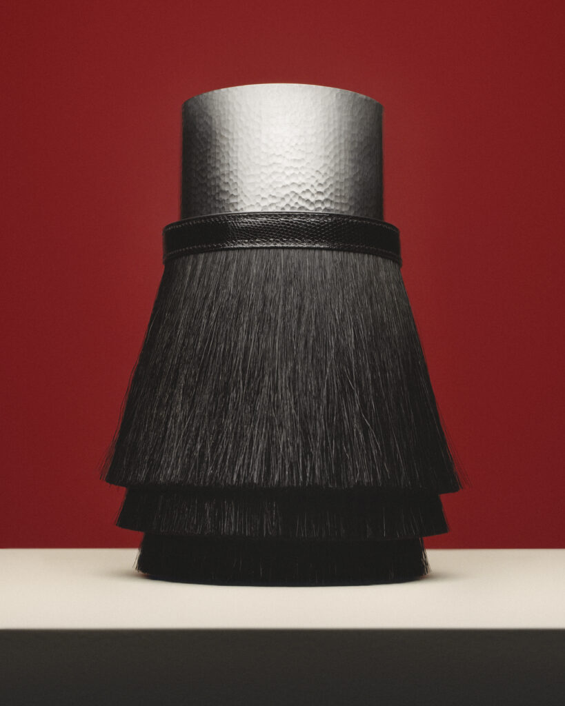 مزهرية Toupet: تباين جريء بين بريق المعدن وعمق شعر الخيل بإلهام من حقيبة أيقونية